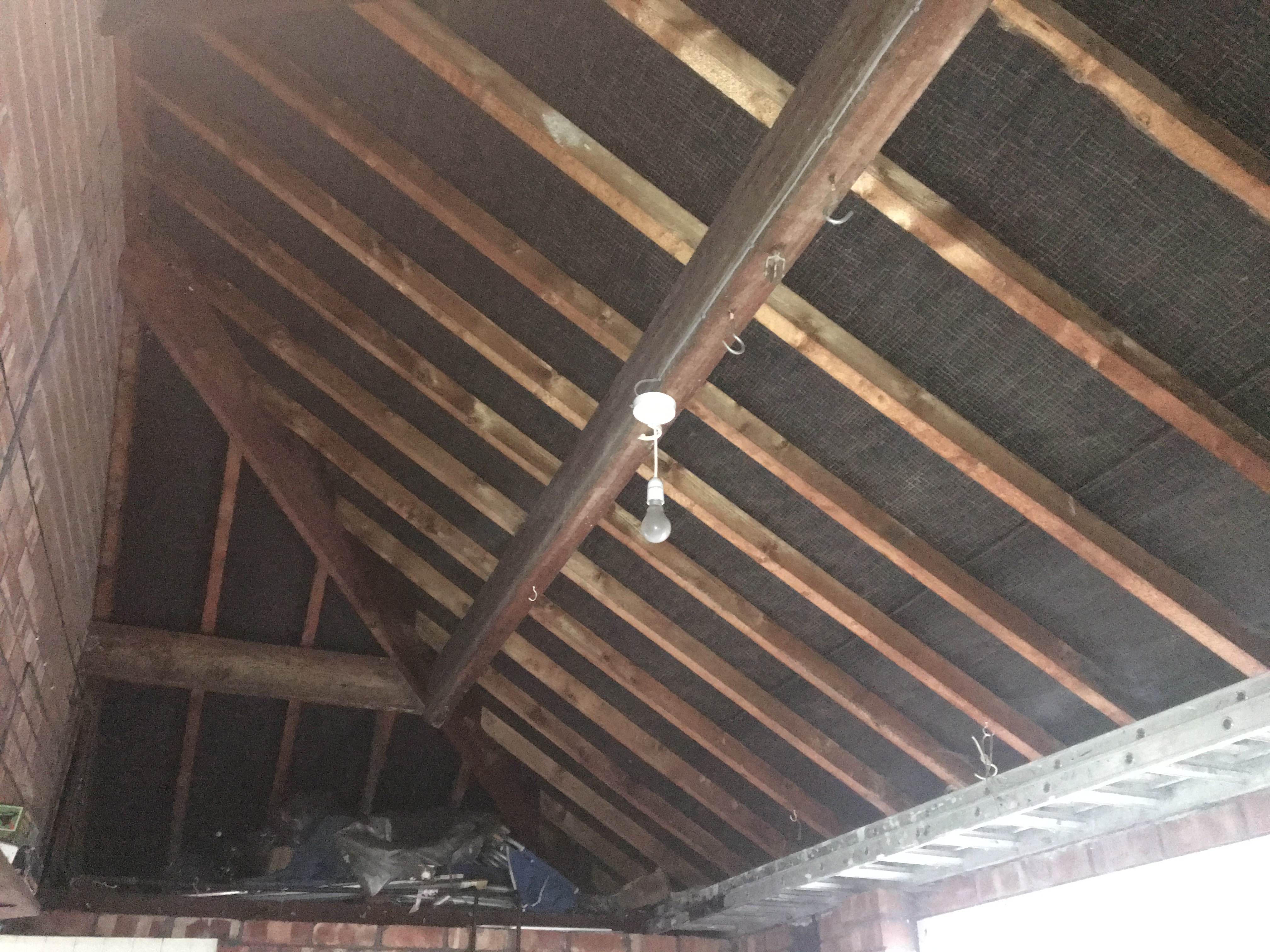 Timber roof structure with rafters and purlins under inspection